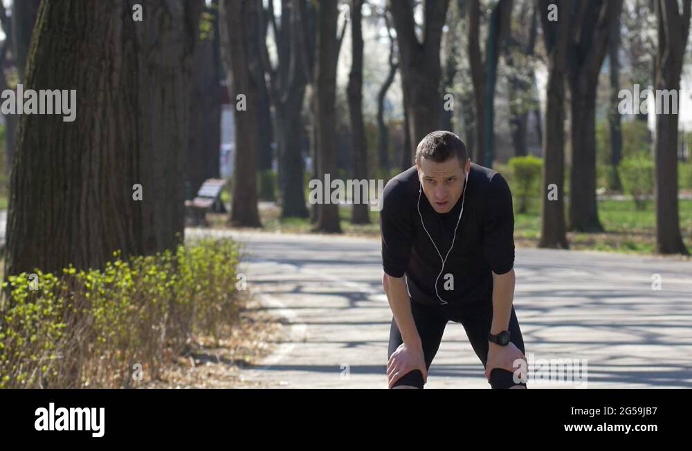 Young athlete in training stopping to catch breath and checking heart