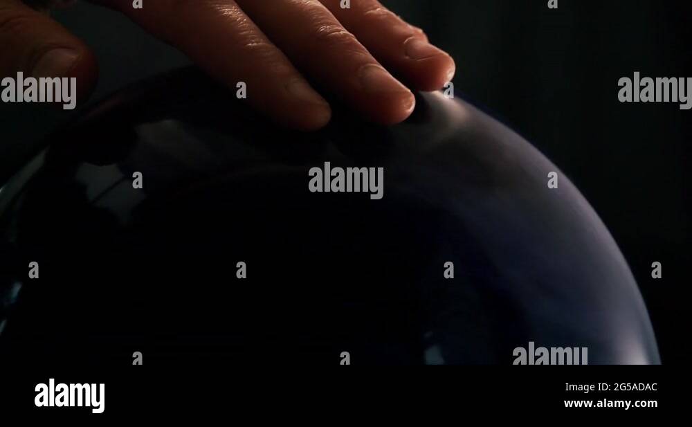 Adult male touching and placing fingers in tenpin bowling ball finger