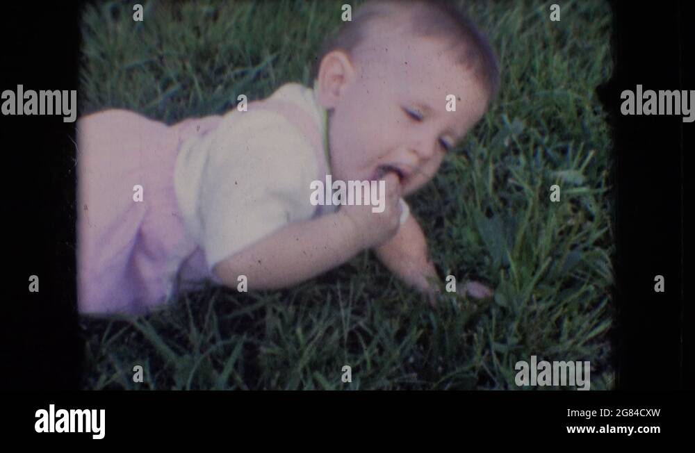 ATHENS OHIO USA1966 A Baby Eating Bugs Off Of Grass But Family Dog