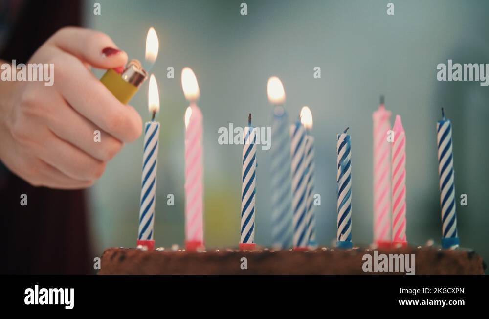Birthday cake with candles. Female hand light candle fire with lighter