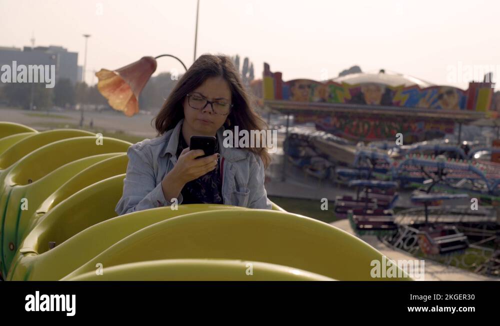 Young girl addictive to a cell phone typing in the roller coaster Stock ...