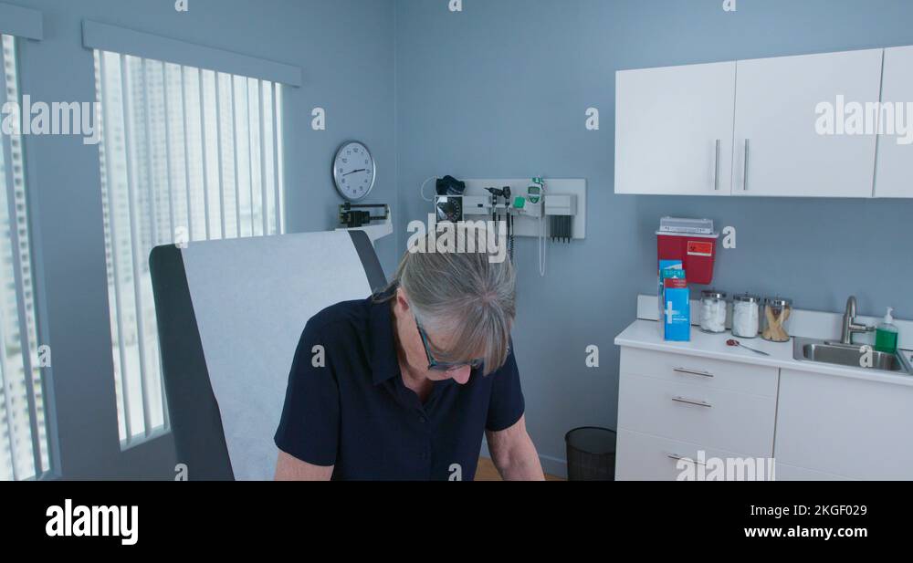 older-woman-patient-sitting-in-medical-exam-room-waiting-for-the-doctor