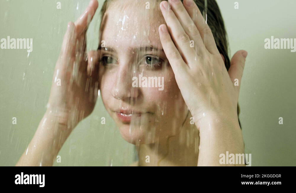 Young beautiful woman taking a shower in a bathroom. Slow motion. HD