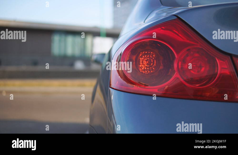 Car hazard lights blinking on the left side of the vehicle close up