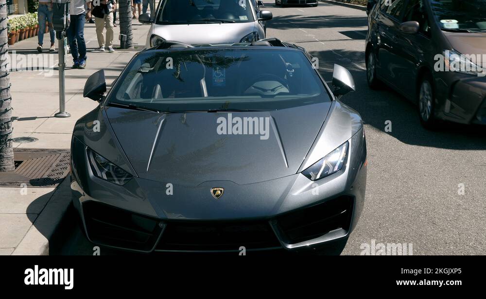 Luxury sports cars driving on Rodeo Drive in Beverly Hills , Los ...
