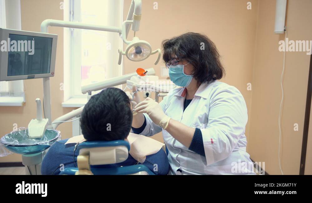 Dentist woman makes an anesthesia injection to a patient before dental