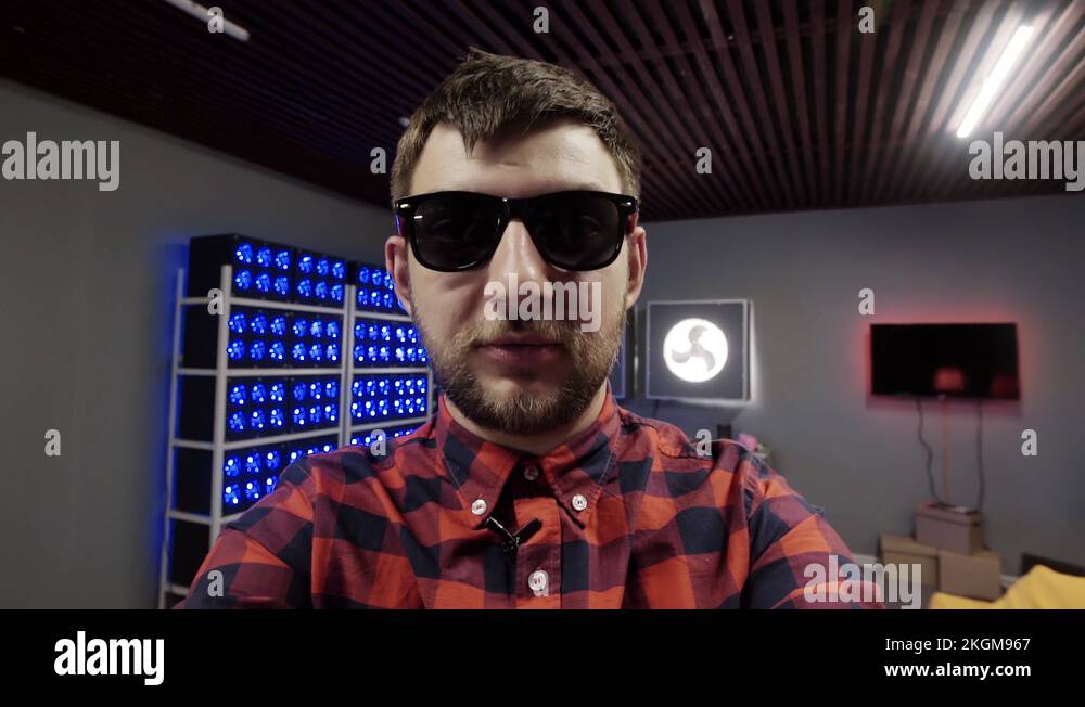 Funny guy with sunglasses holds camera in hands and aggressively speaks