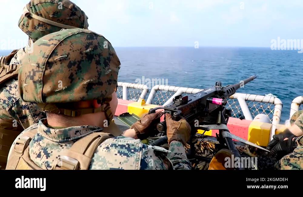 Soldier firing machine gun from boat into the ocean Stock Video Footage