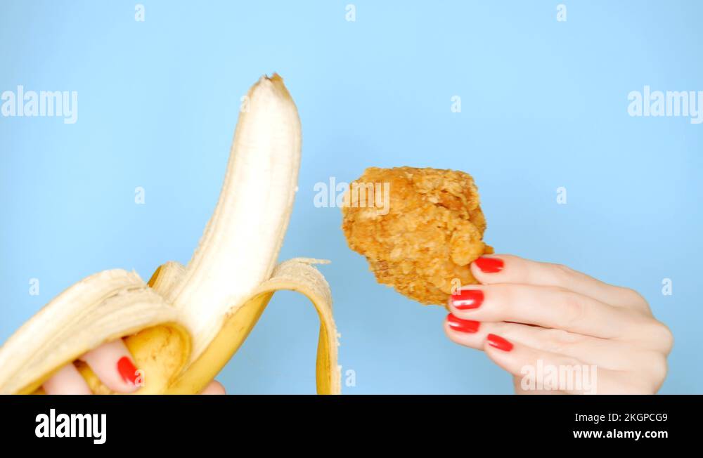 Concept of healthy and unhealthy food. banana against fried breaded chicken leg Stock Video