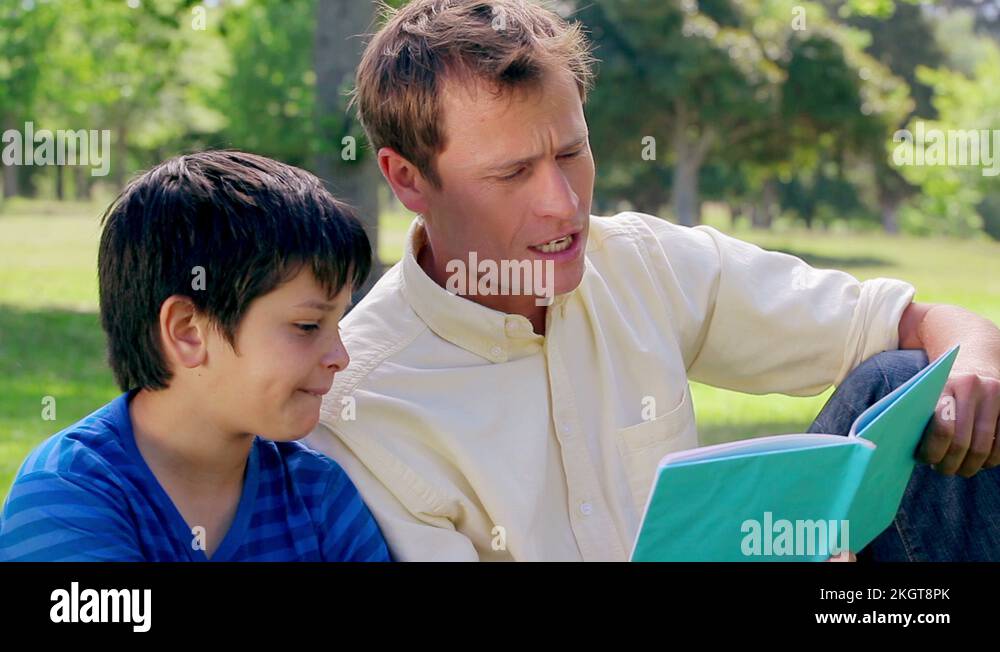 Father reading with son outdoors Stock Videos & Footage HD and 4K