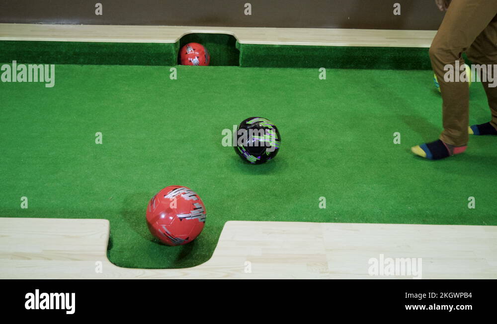 Two men playing billiards, hitting balls into holes on a floor billiard table 4K Stock Video