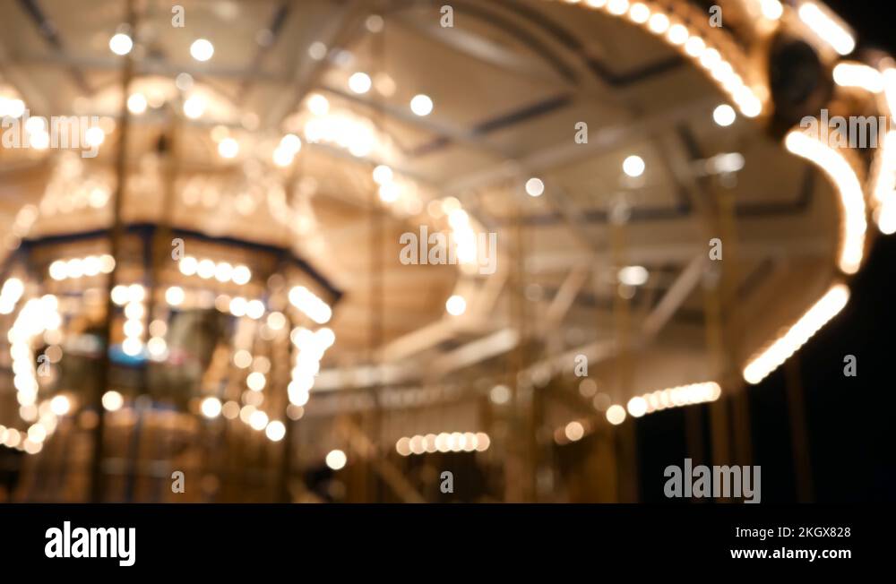 Illuminated blurred merry go round in park. Brightly illuminated