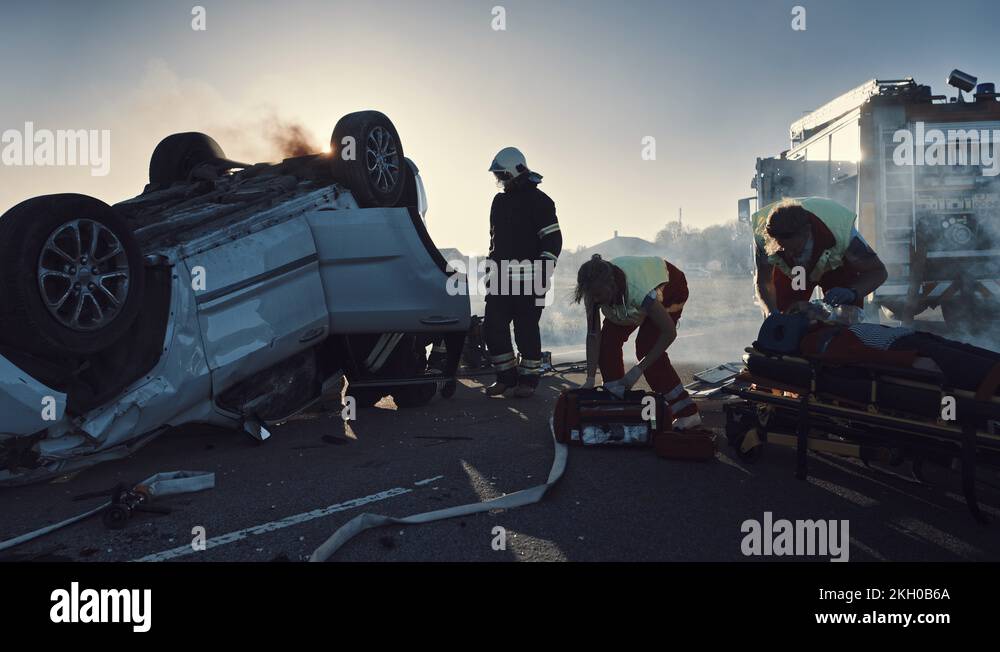 On the Car Crash Traffic Accident Scene Paramedics Giving First Aid