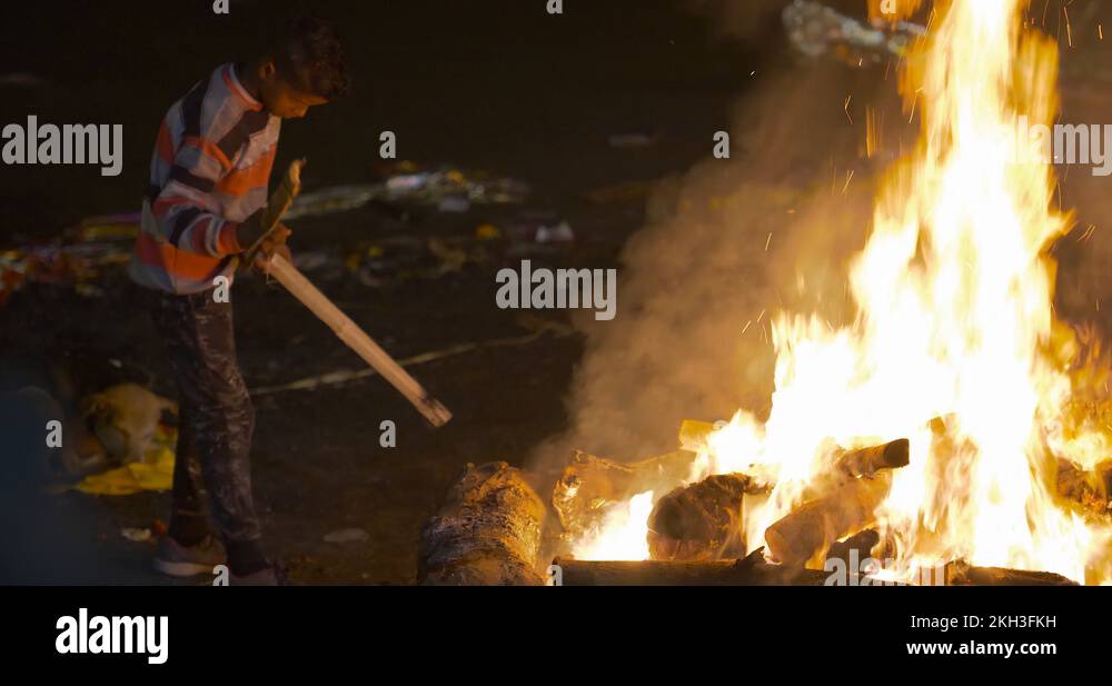 Young poor boy burning dead bodies in Manikarnika Ghat, Varanasi, India