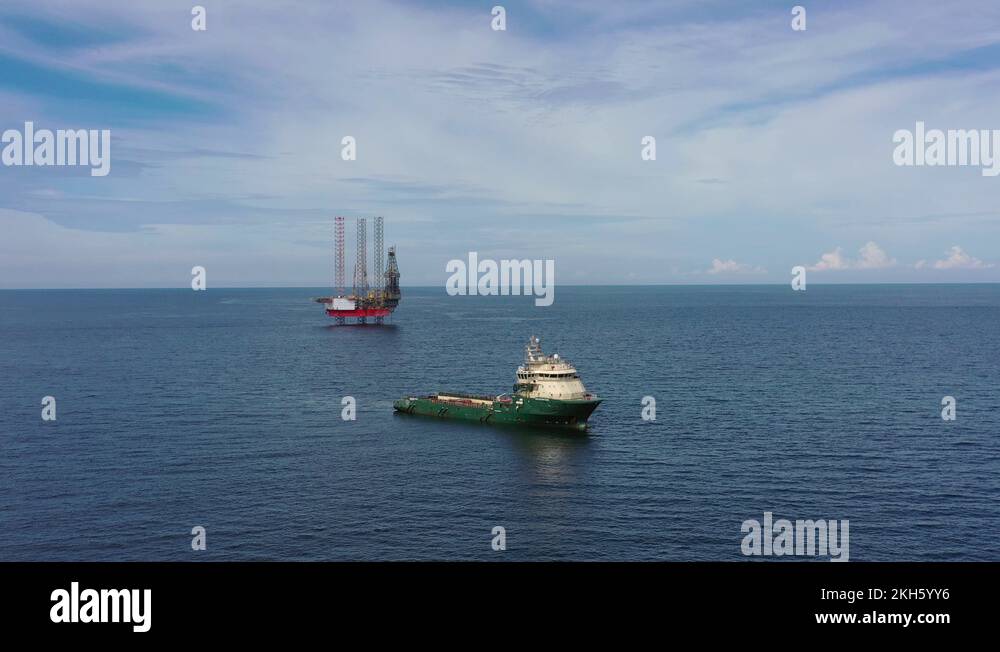 Offshore jackup drilling rig and a standby vessel Stock Video Footage