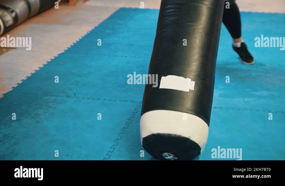 A man bodybuilder lift up and carrying the punching bag on the shoulder