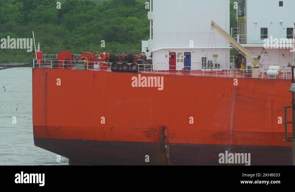 orange color stern of a oil tanker proceeding to the berth in a port
