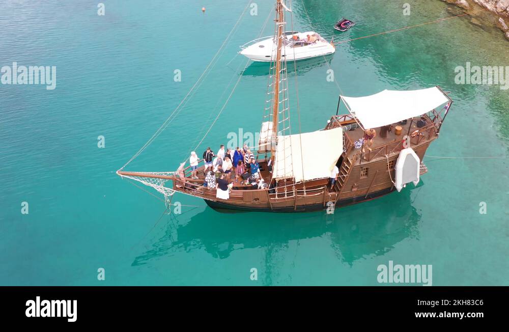Party crowd on pirate ship in colourful bay - Jumping from boat Stock ...