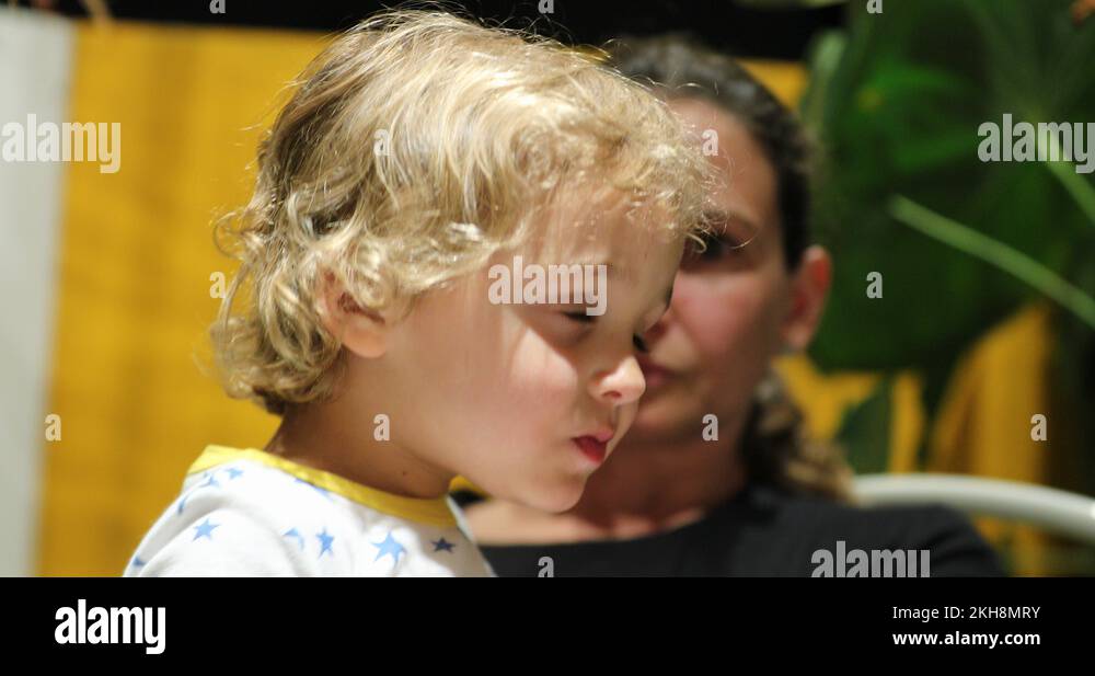 Toddler leaning to mother chest falling asleep candid and authentic