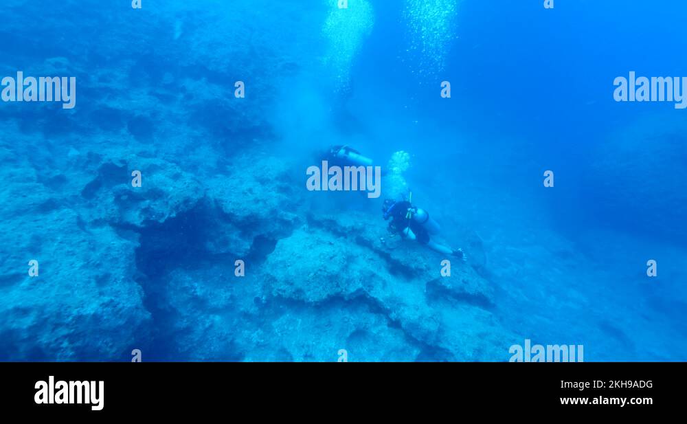 scuba divers picking old fishing nets cages to prevent ghost hunting