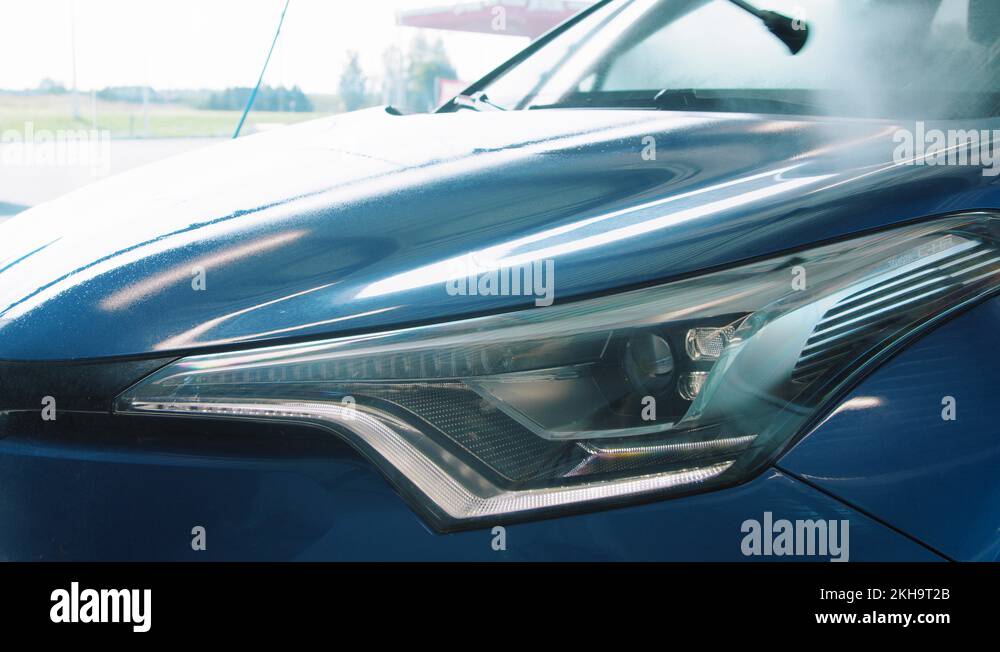 Spraying presoak on the hood and headlight in self service car wash