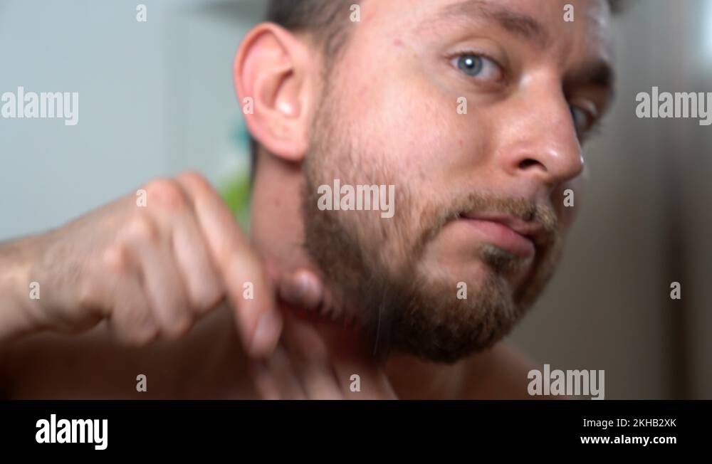 Stylish barber male showing the way of beard treatment at home