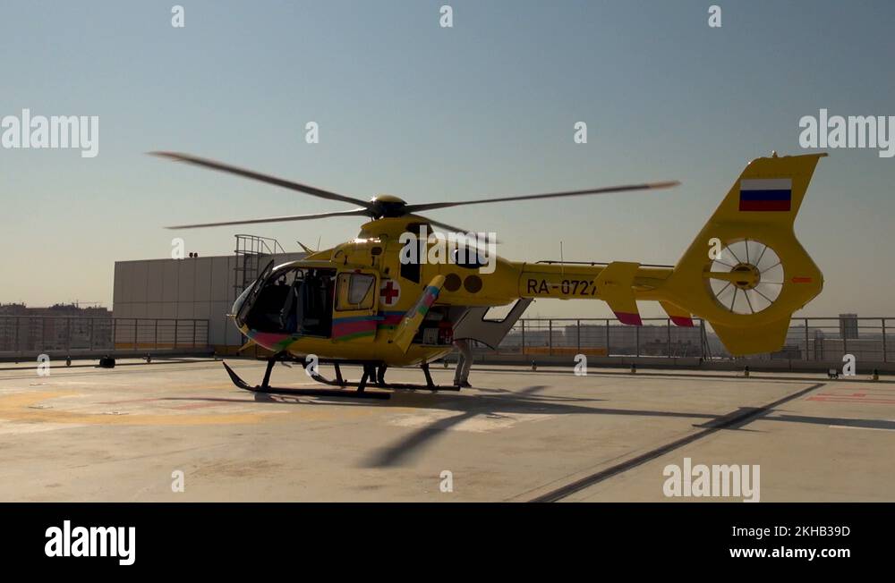 EC135 medical helicopter on roof hospital building with rotating blades ...