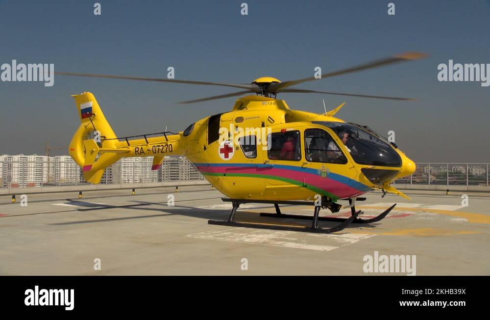 EC135 medical helicopter on roof hospital building with rotating blades