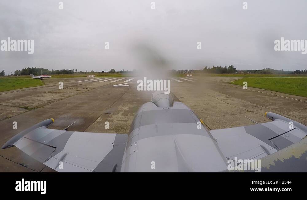 Jet plane rides along the strip of the old airfield on dark cloudy day