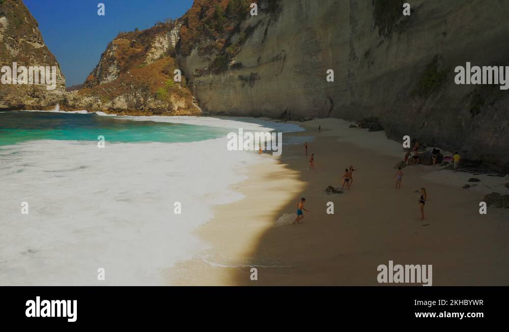 Tourist people swim in big waves on Diamond beach in Nusa Penida island
