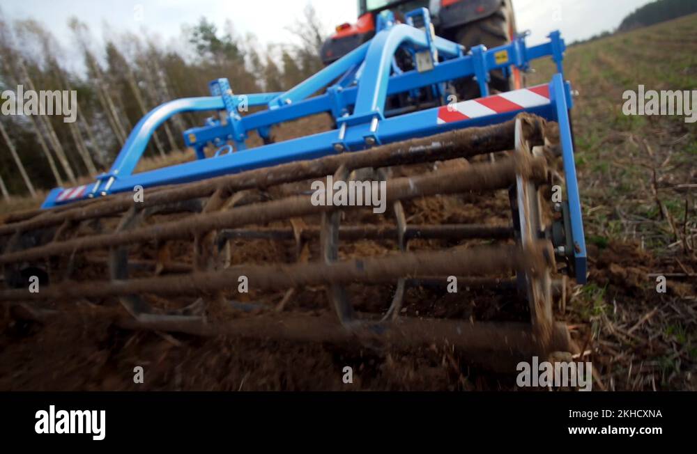 Following farm machinery tractor turning & ploughing farm soil field