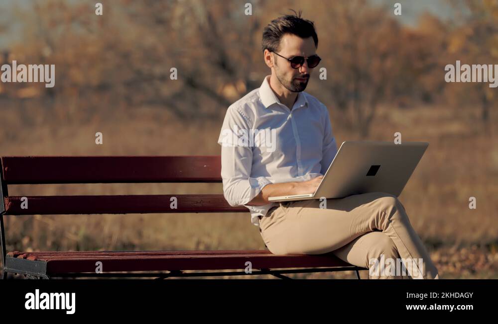 Man Sitting On Bench And Working On Laptop.Creative Man With Computer ...