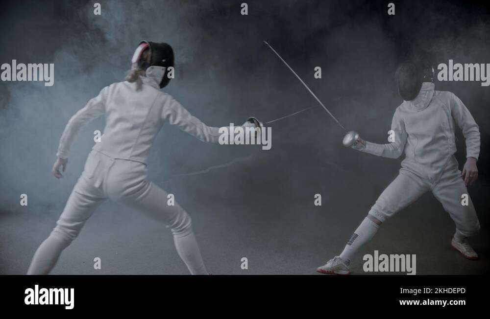 Fencing training two young women having a duel in the smoky studio Stock Video Footage Alamy