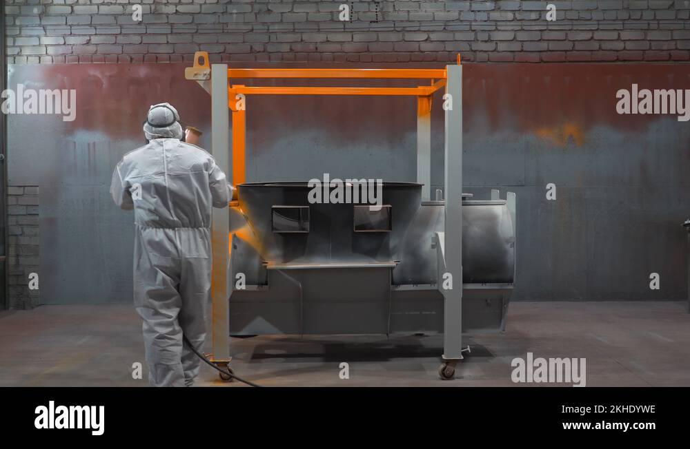 Paint and varnish hangar, man in chemical protection suit works as