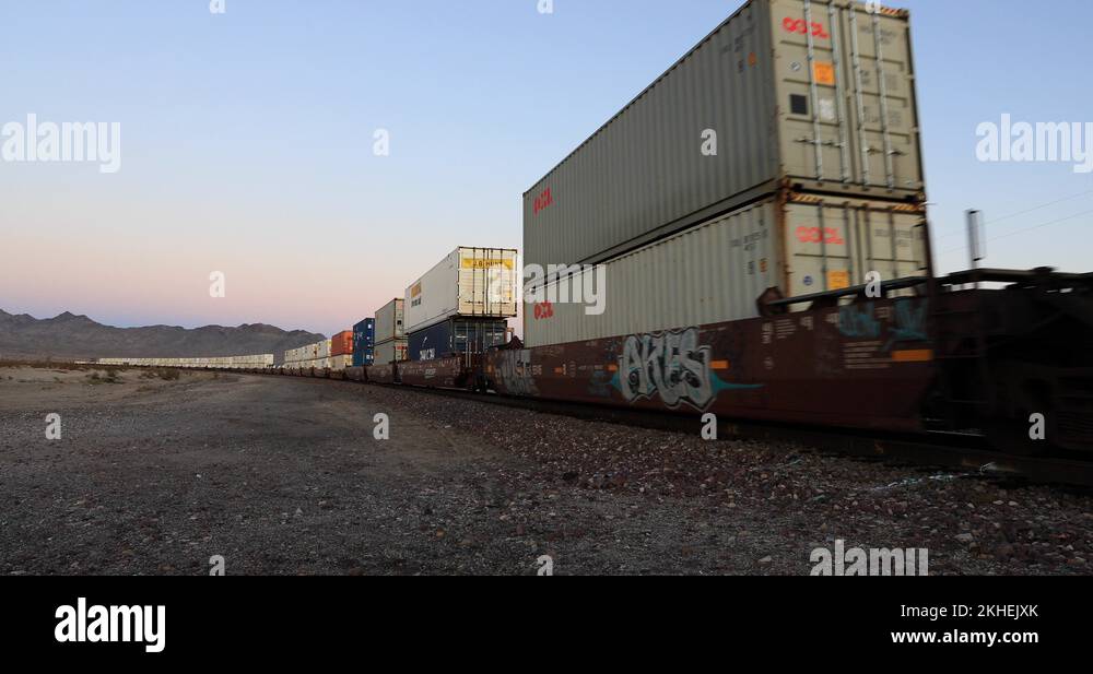 Railroad container train desert highway crossing sunset 4K Stock Video