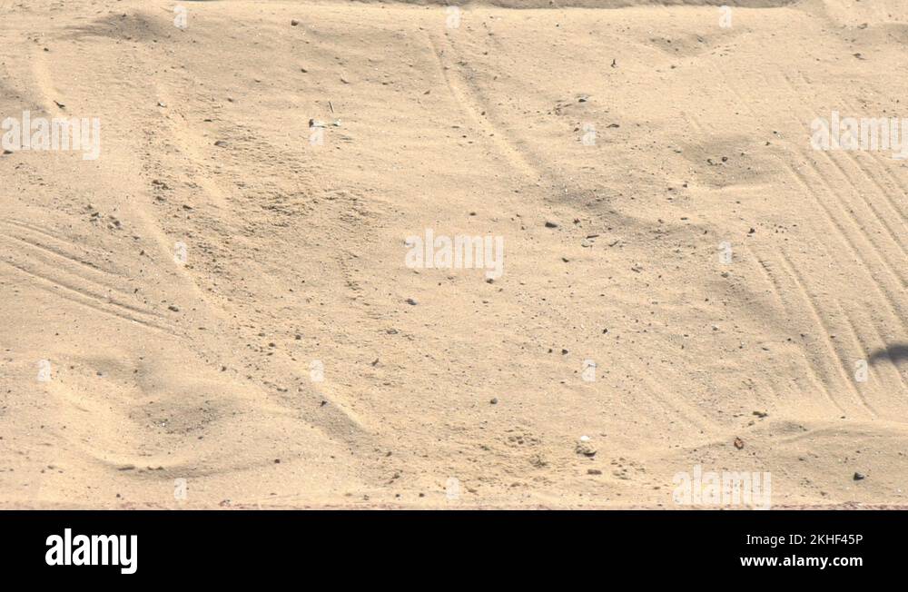 Sportsman doing long jump landing in sandpit. Track and field