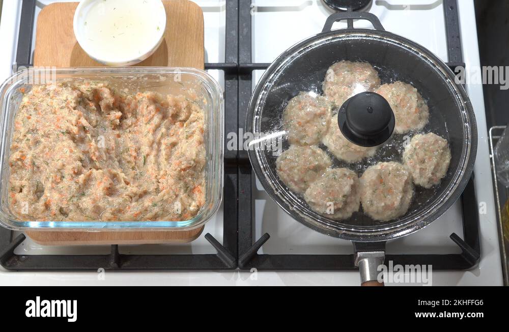 Making pan fried chicken cutlets in cast iron frying skillet on gas