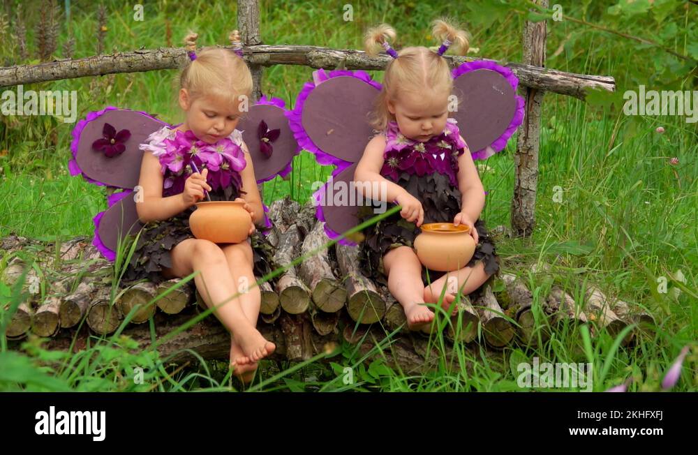 Girls with butterfly wings eat honey with a spoon Stock Video Footage