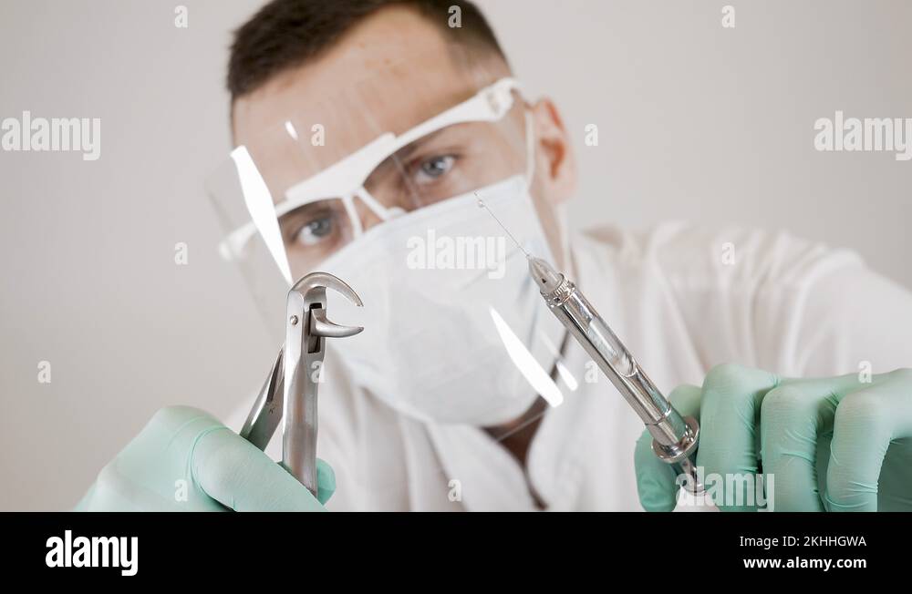 Dentist releases air bubbles from a syringe, holding forceps in his