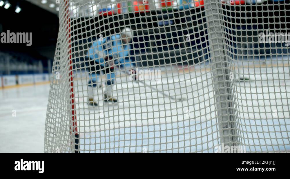 Hitting puck player hockey in gate close up people score goal slow mo