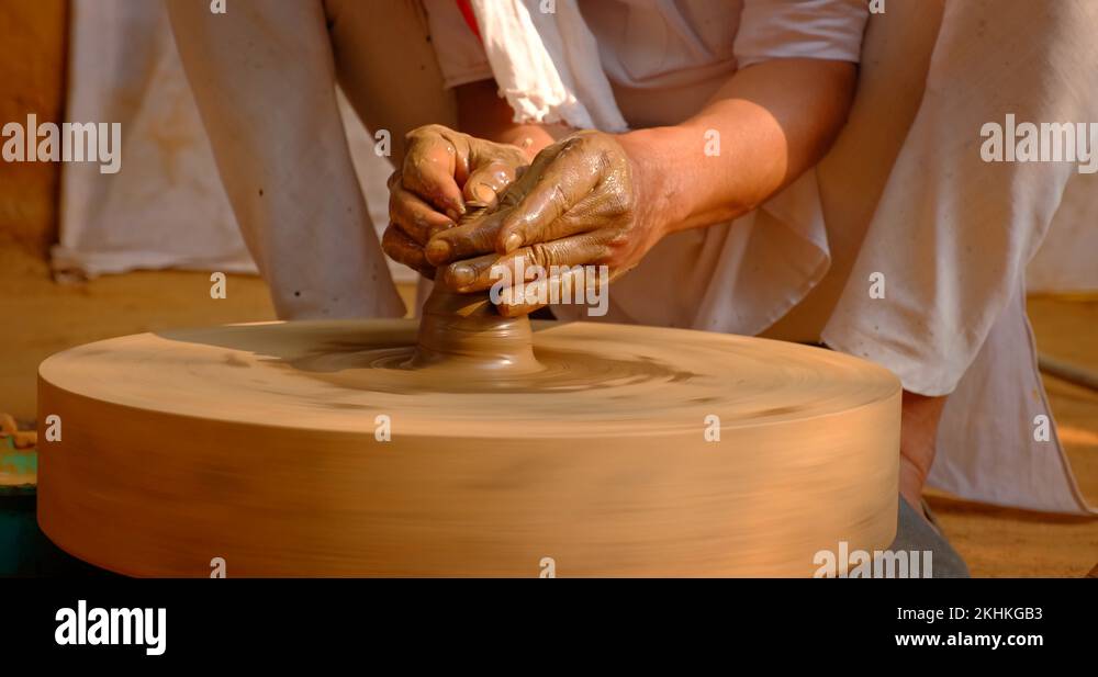 Skilled hands of potter shaping the clay on potter wheel and sculpting ...