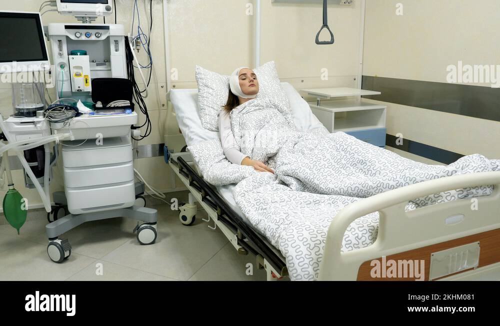 Female patient after plastic surgery lying on her bed in hospital ward