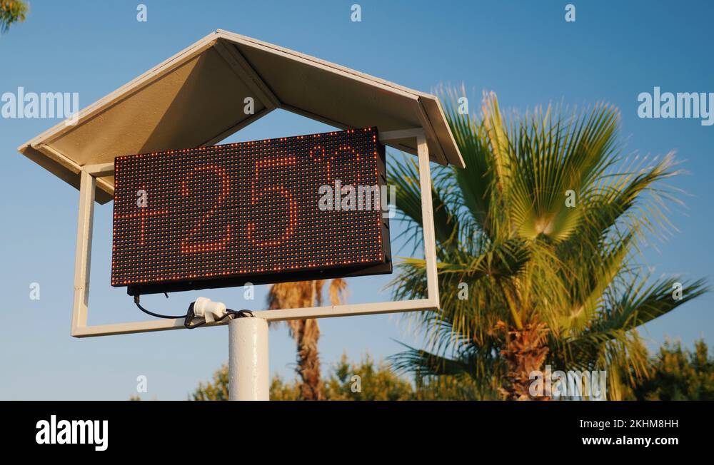 The thermometer's scoreboard on the beach shows the temperature is 25