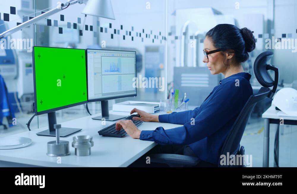 Female Engineer Working on a PC, Two Monitor Screens Show Chroma Key