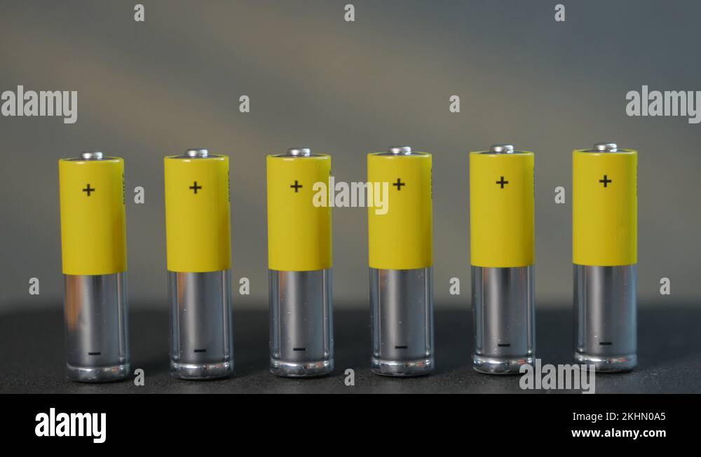 The concept of a closeup of seven AA batteries, male finger, tilt the