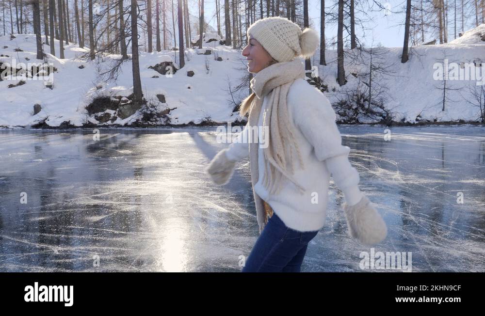 Young woman ice skating on frozen lake in winter Stock Video Footage ...