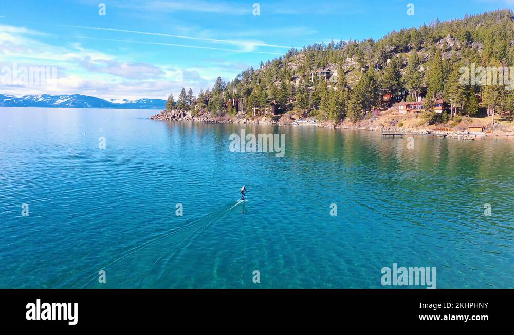 2020 a man rides a hydrofoil efoil electronic surfboard across Lake