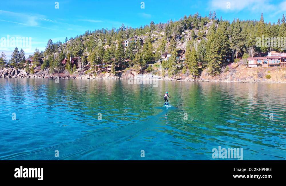 2020 a man rides a hydrofoil efoil electronic surfboard across Lake