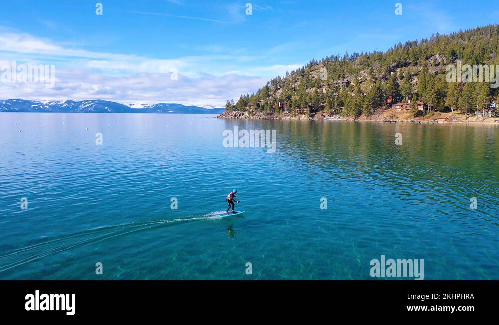 2020 a man rides a hydrofoil efoil electronic surfboard across Lake