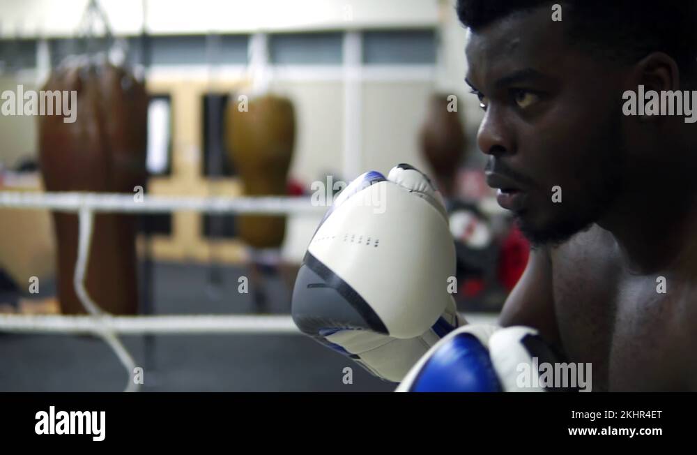 Cinematic Black Male Boxer Training With Pads In Boxing Ring Stock